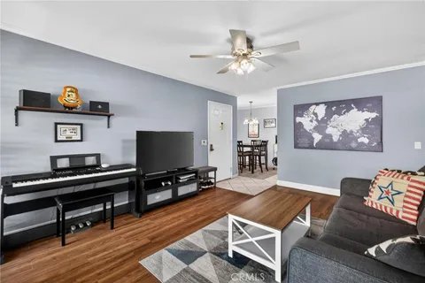 a living room with furniture a desk and chair with wooden floor