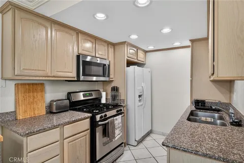 a kitchen with stainless steel appliances granite countertop a stove a refrigerator and a sink