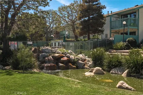 a backyard of a house with lots of green space and fountain