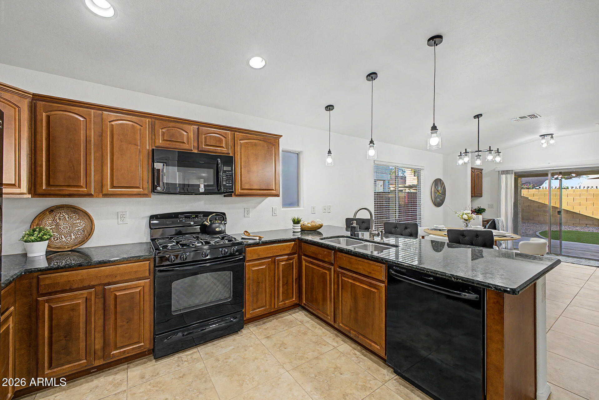 4168 East Sandy Way Gilbert, AZ 85297 - Photo 11 of 47 a kitchen with stainless steel appliances granite countertop a sink a stove a microwave and wooden cabinets