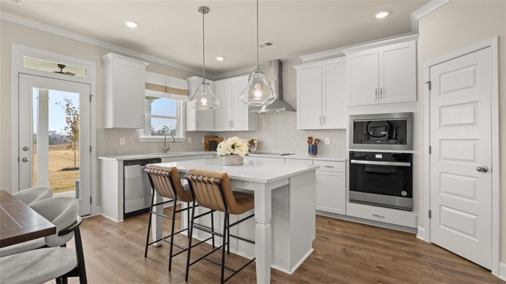 1915 Endress Circle Hampton, GA 30228 - Photo 20 of 42 a kitchen with a table chairs stove and cabinets