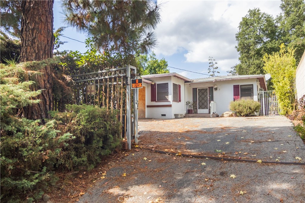 a front view of a house with a yard and potted plants