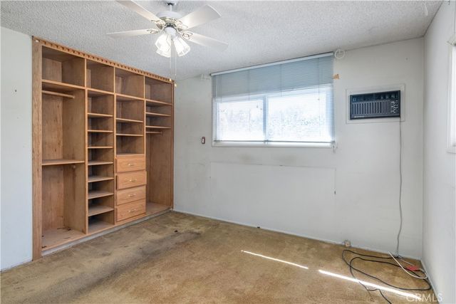 a view of an empty room with a window and closet