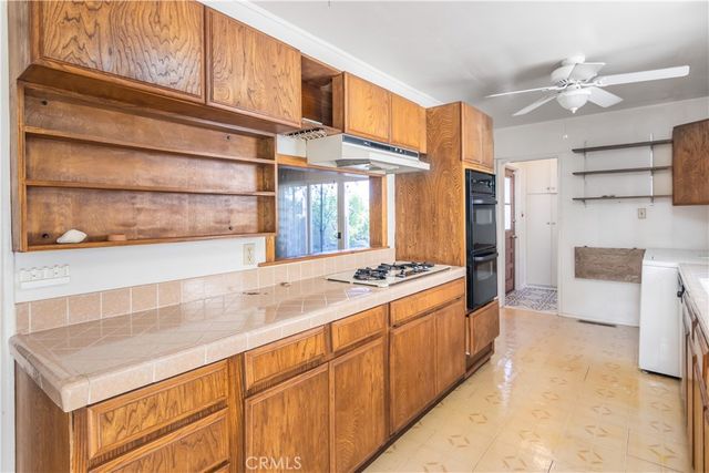 a kitchen with stainless steel appliances granite countertop a refrigerator a stove and a sink with cabinets