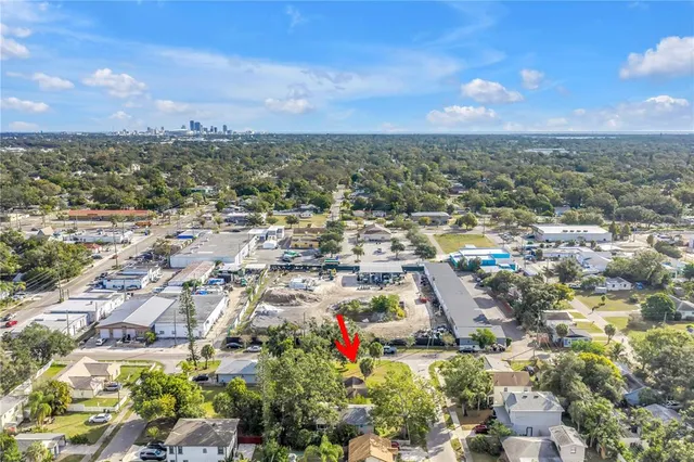an aerial view of residential houses with outdoor space and trees