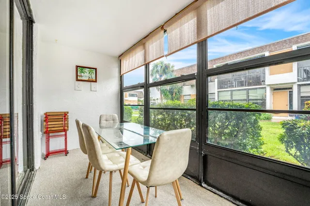 a dining room with furniture large windows and wooden floor