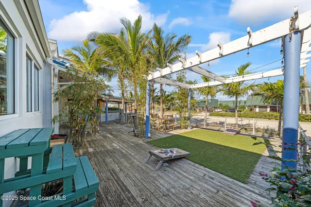 a view of yard from deck with patio