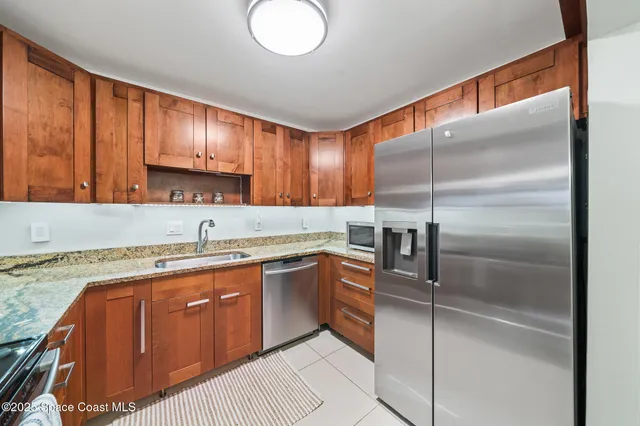 a kitchen with stainless steel appliances granite countertop a sink a stove and a refrigerator