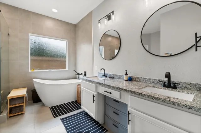 a spacious bathroom with a granite countertop toilet a sink and a mirror