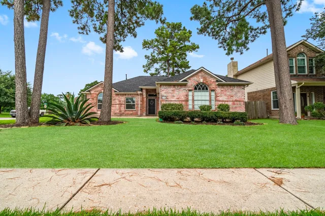 a front view of a house with a garden and trees