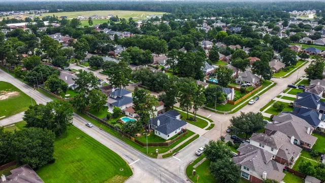 an aerial view of residential houses with outdoor space and street view