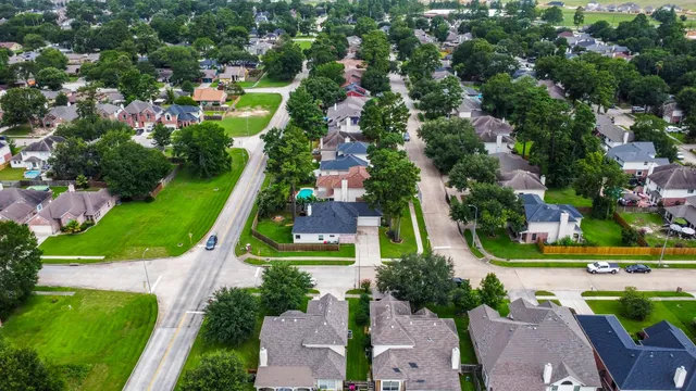 an aerial view of residential houses with outdoor space and trees