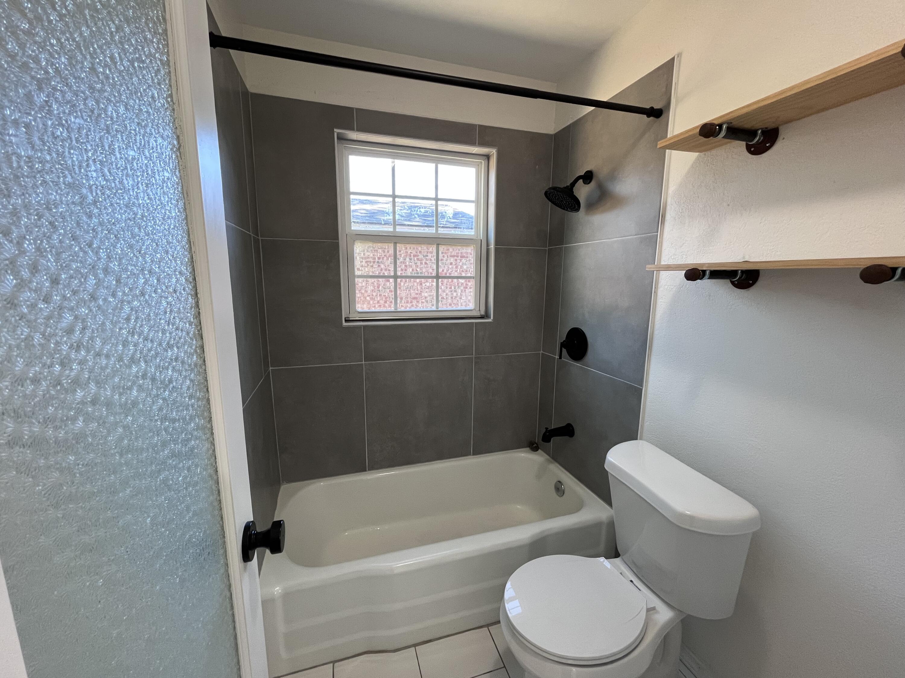 3612 55th Street Lubbock, TX 79413 - Photo 19 of 28 a white toilet sitting next to a bath tub