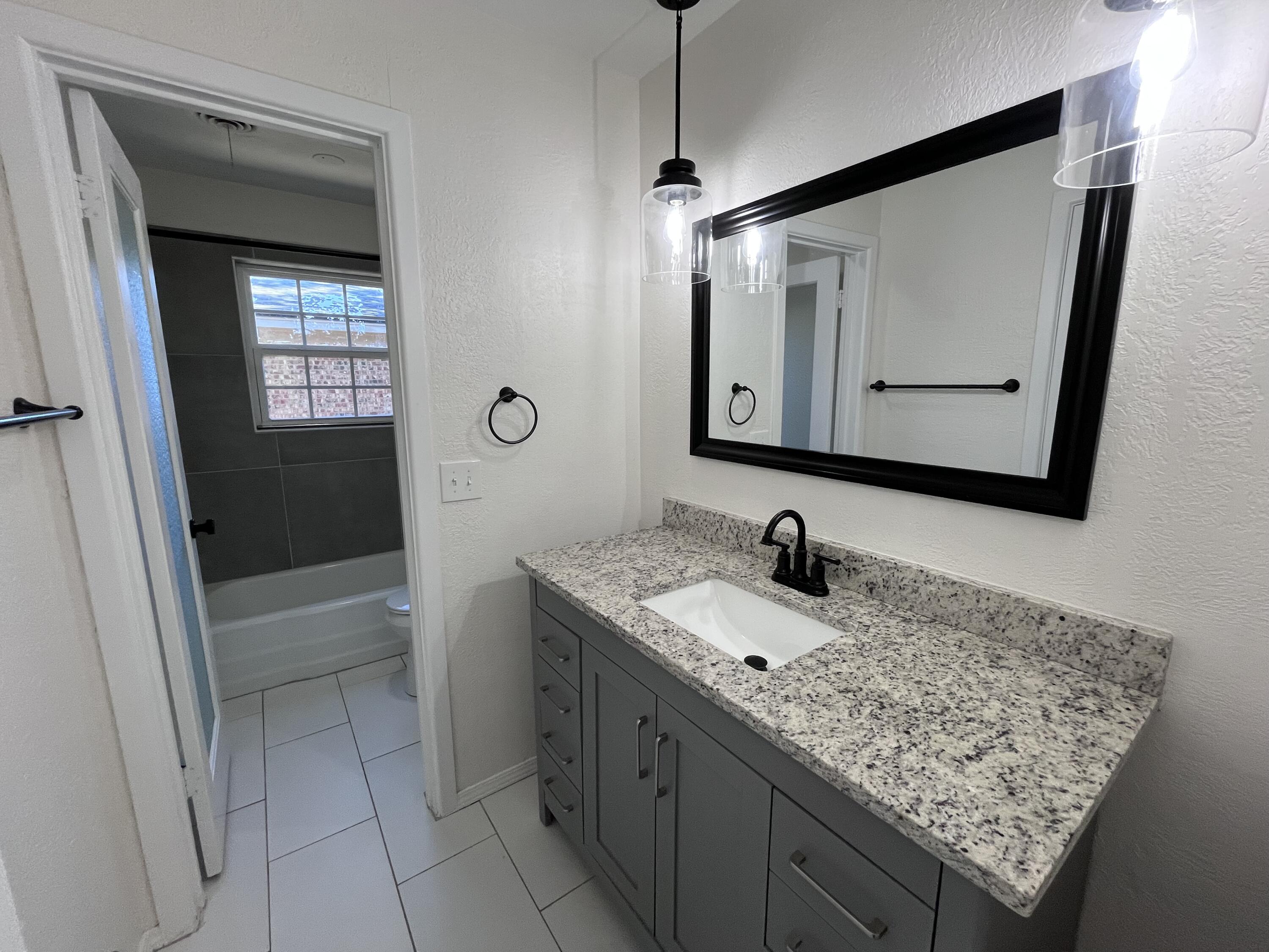 3612 55th Street Lubbock, TX 79413 - Photo 20 of 28 a bathroom with a granite countertop sink a mirror and shower