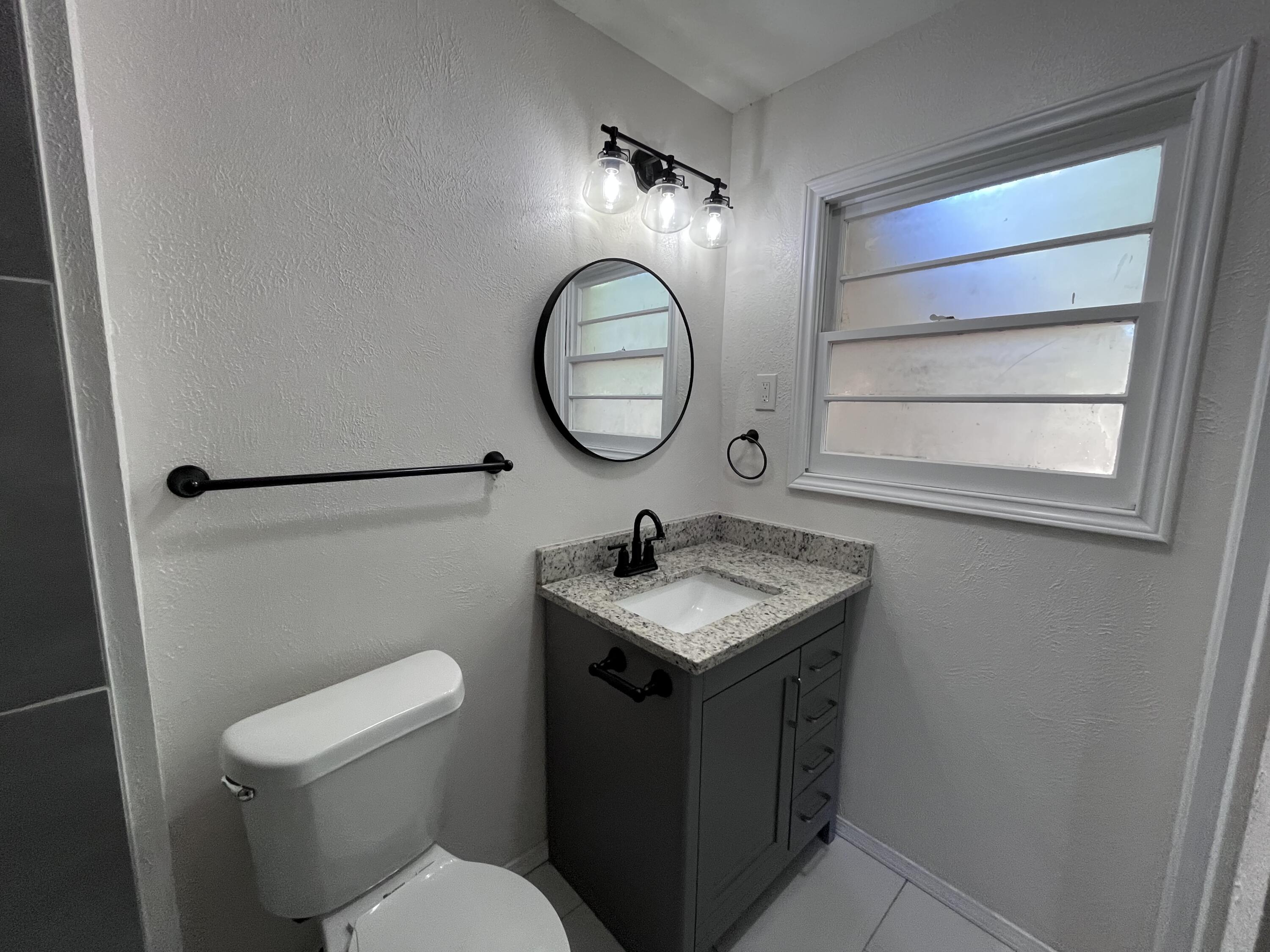 3612 55th Street Lubbock, TX 79413 - Photo 22 of 28 a bathroom with a toilet a sink and a mirror