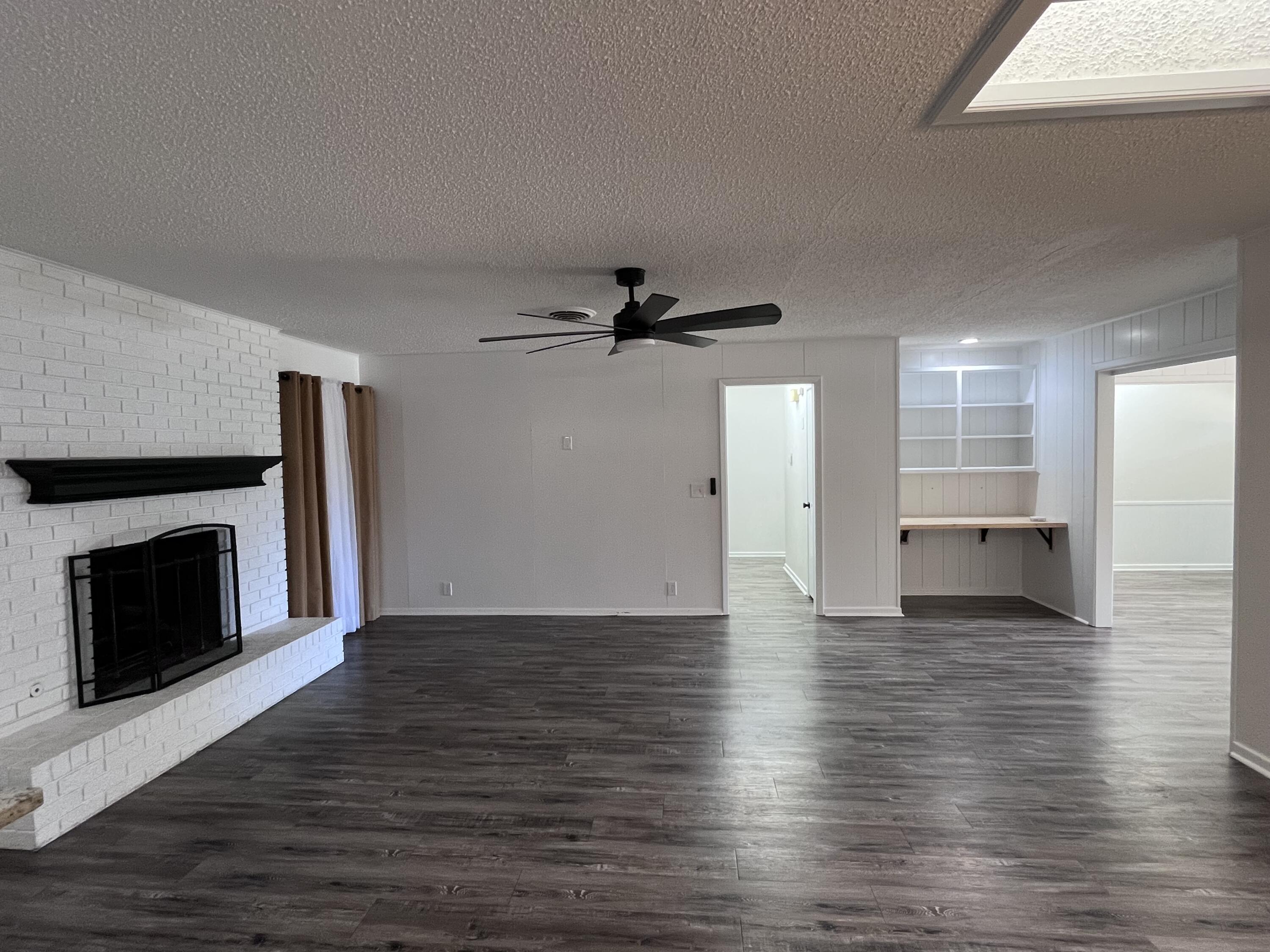 3612 55th Street Lubbock, TX 79413 - Photo 6 of 28 a view of a livingroom with wooden floor and a fireplace