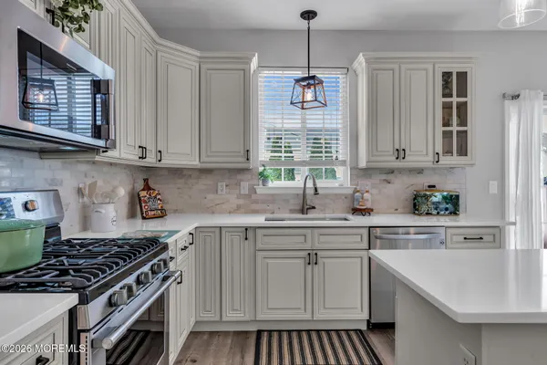 a kitchen with cabinets appliances and a window