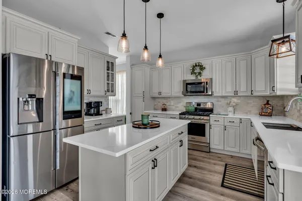a kitchen with white cabinets and stainless steel appliances