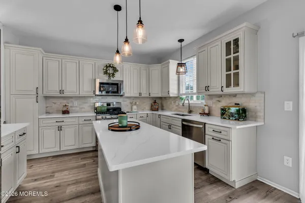 a kitchen with a sink white cabinets and white appliances