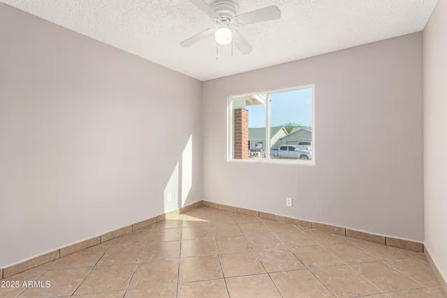 an empty room with windows and fan