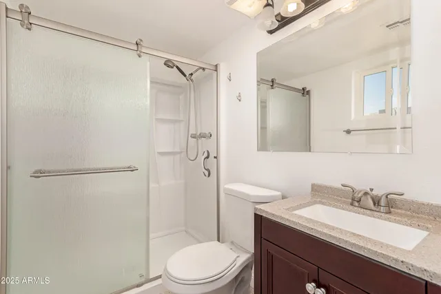 a bathroom with a granite countertop sink toilet and shower