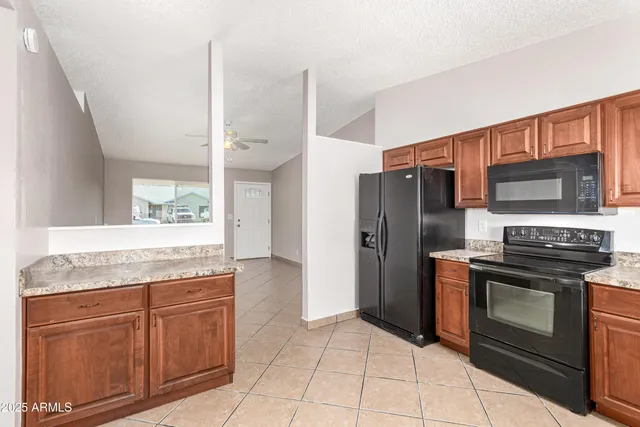 a kitchen with stainless steel appliances granite countertop a refrigerator and a stove top oven