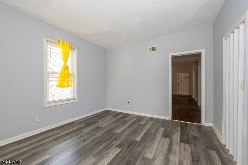 156 East Main Street Paterson, NJ 07522 - Photo 16 of 25 a view of an empty room with wooden floor and a window