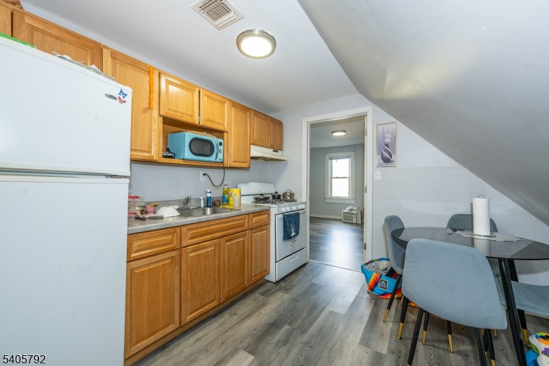 156 East Main Street Paterson, NJ 07522 - Photo 21 of 25 a kitchen with stainless steel appliances a stove a sink cabinets and a dining table