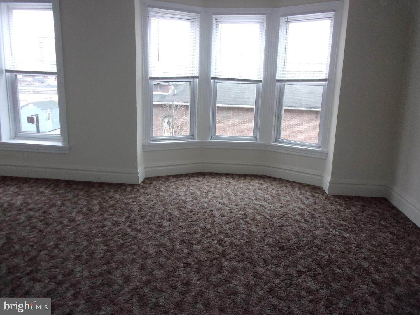 19 North Front Street Steelton, PA 17113 - Photo 9 of 14 an empty room with wooden floor and windows