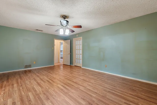 a view of an empty room with wooden floor