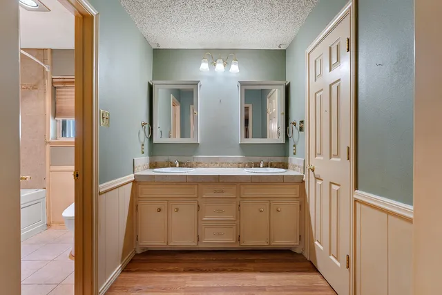 a spacious bathroom with a double vanity sink and a mirror