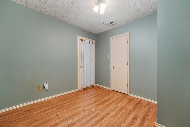 a view of a room with wooden floor and white walls