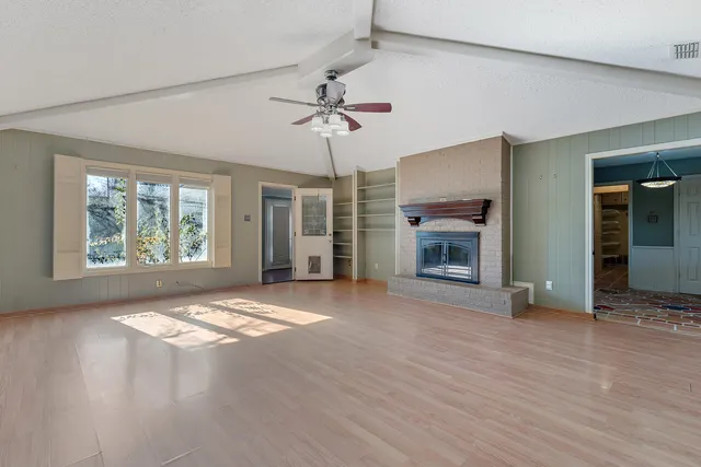 an empty room with windows and a fireplace