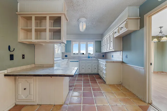 a kitchen with a sink window and cabinets