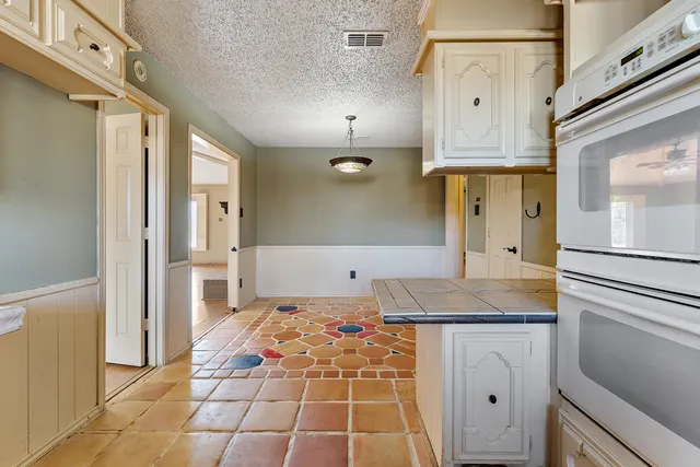a bathroom with a granite countertop sink a toilet a mirror and shower