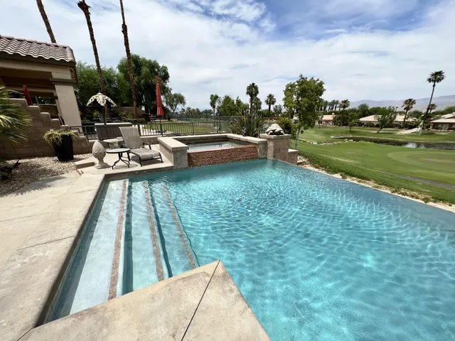 a view of swimming pool from a lounge chairs