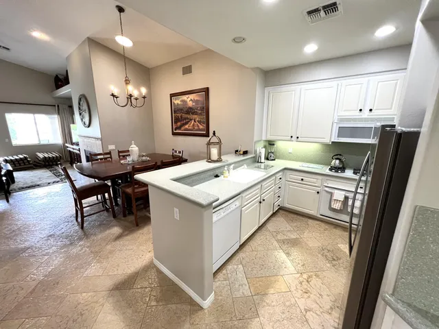 a kitchen that has a sink a table and chairs in it