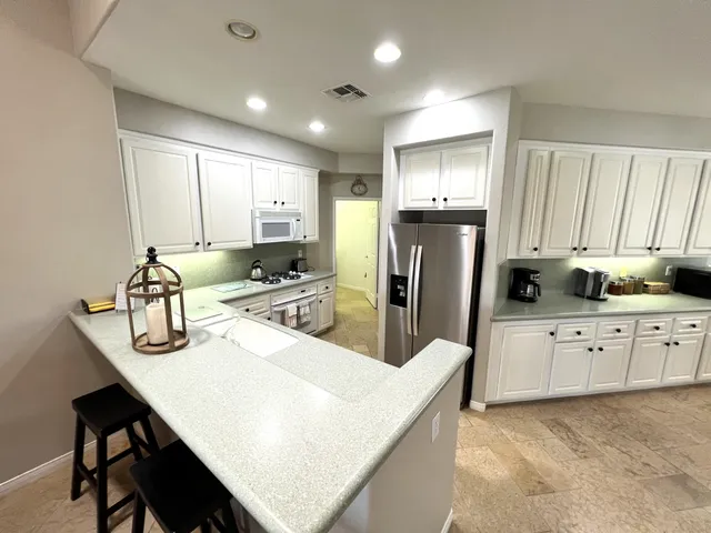 a kitchen with refrigerator cabinets and large window
