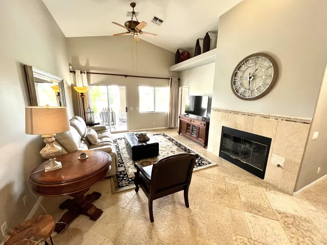 a living room with furniture a fireplace and a large window