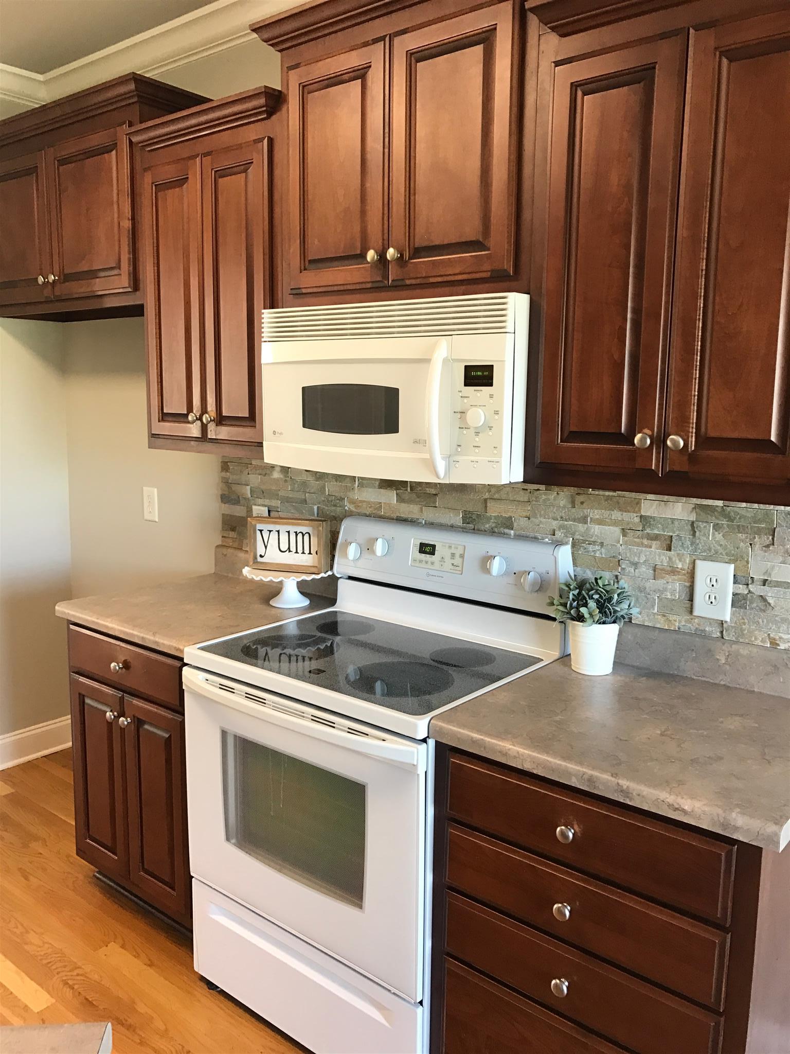 703 Heritage Road Lebanon, TN 37087 - Photo 8 of 28 a kitchen with wooden cabinets and a stove top oven