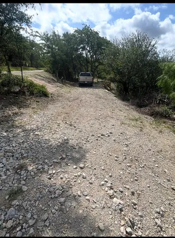 a view of a yard with trees in the background