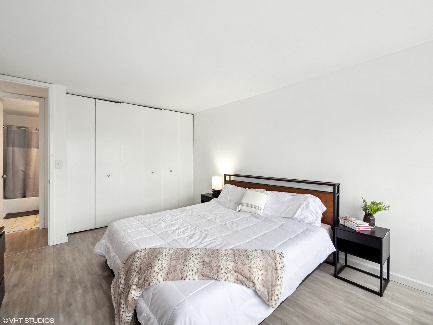 655 West Irving Park Road, Unit 2303 Chicago, IL 60613 - Photo 8 of 13 a bedroom with a bed and wooden floor