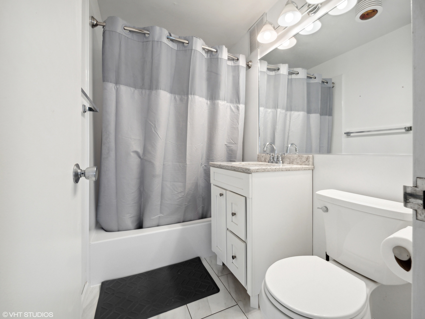 655 West Irving Park Road, Unit 2303 Chicago, IL 60613 - Photo 9 of 13 a bathroom with a sink a toilet a shower curtain and a mirror