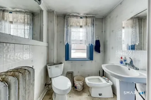 a bathroom with a toilet sink and mirror