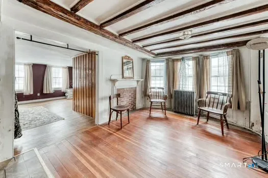 a view of a hallway with wooden floor and furniture