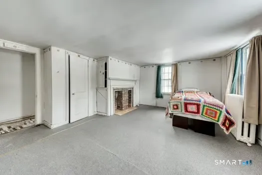 a bedroom with furniture and a fireplace