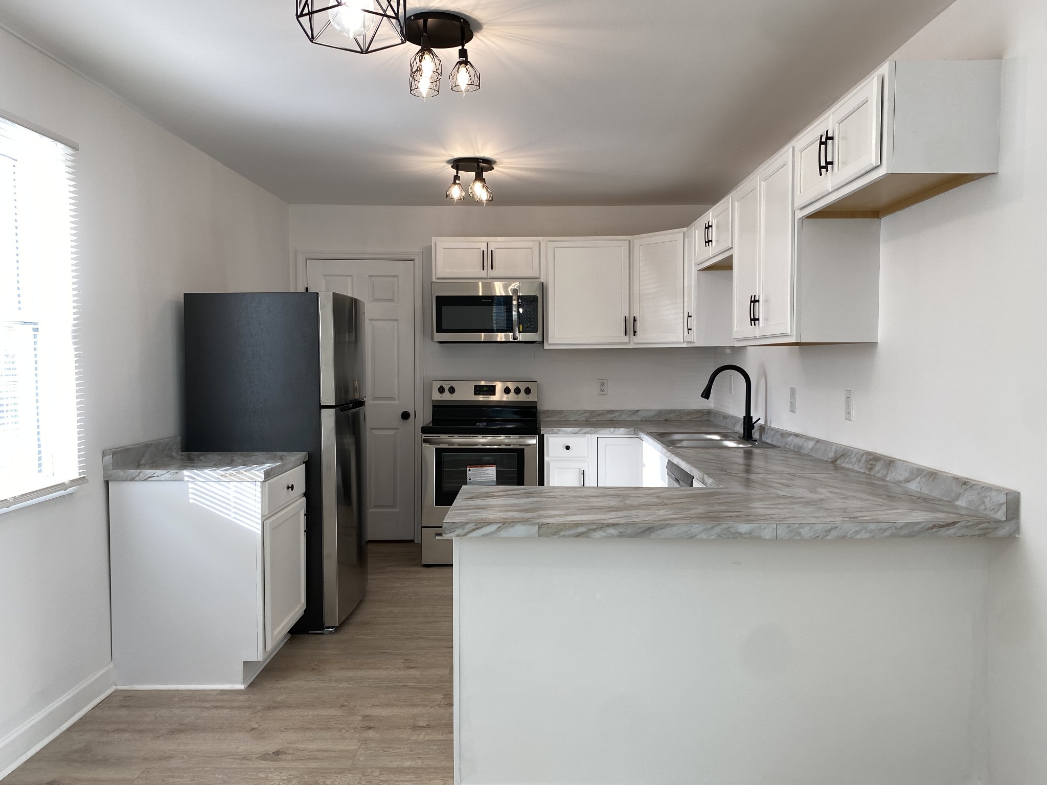 245 Raintree Drive Clarksville, TN 37042 - Photo 5 of 33 a kitchen with stainless steel appliances granite countertop a refrigerator a stove a sink a microwave and wooden cabinets