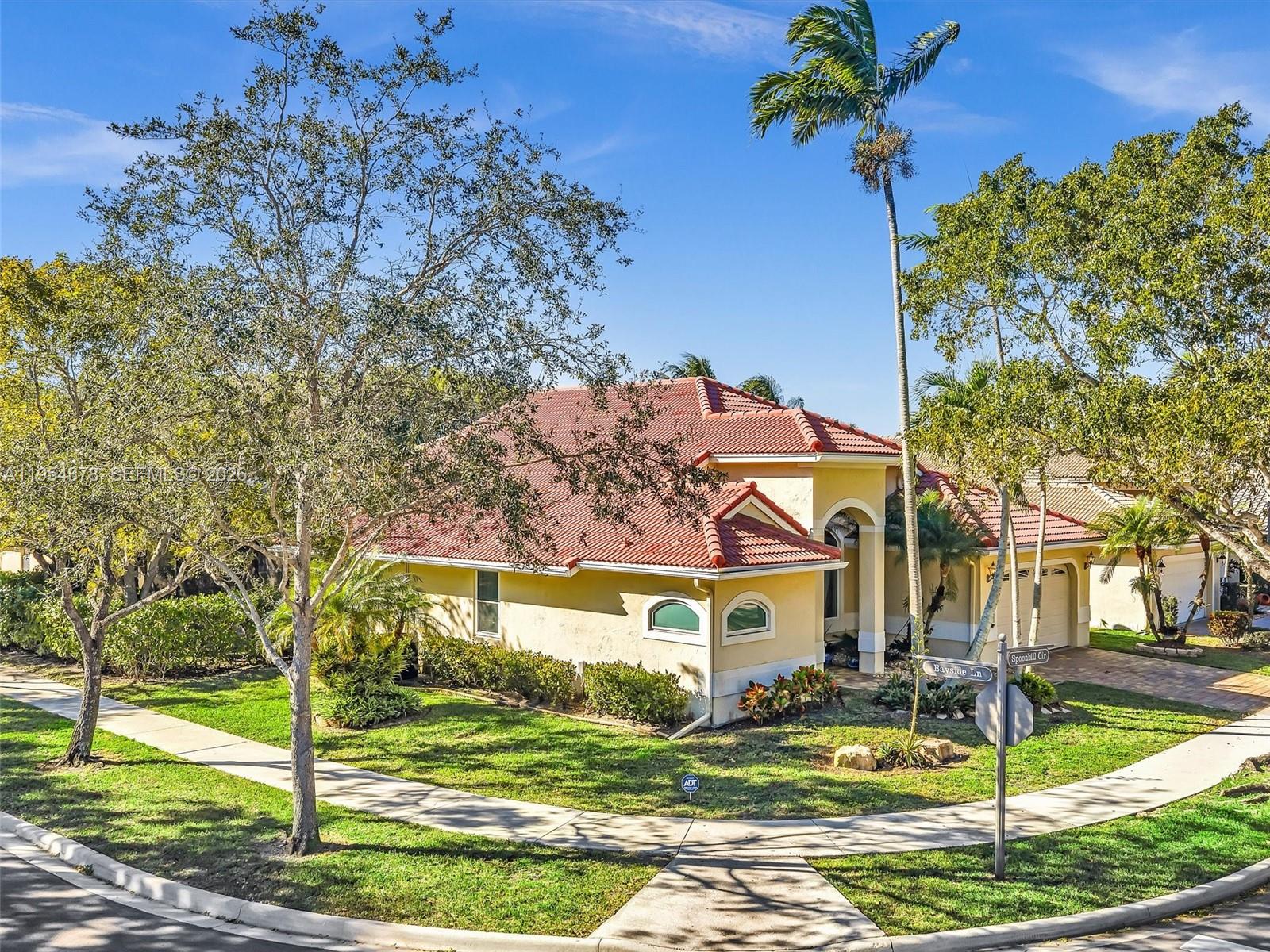 900 Spoonbill Circle Weston, FL 33326 - Photo 2 of 51 a front view of a house with garden