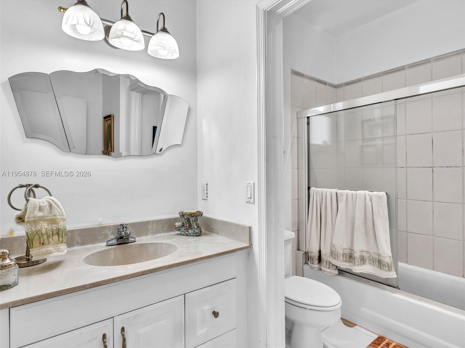 900 Spoonbill Circle Weston, FL 33326 - Photo 32 of 51 a bathroom with a granite countertop sink a toilet and a mirror