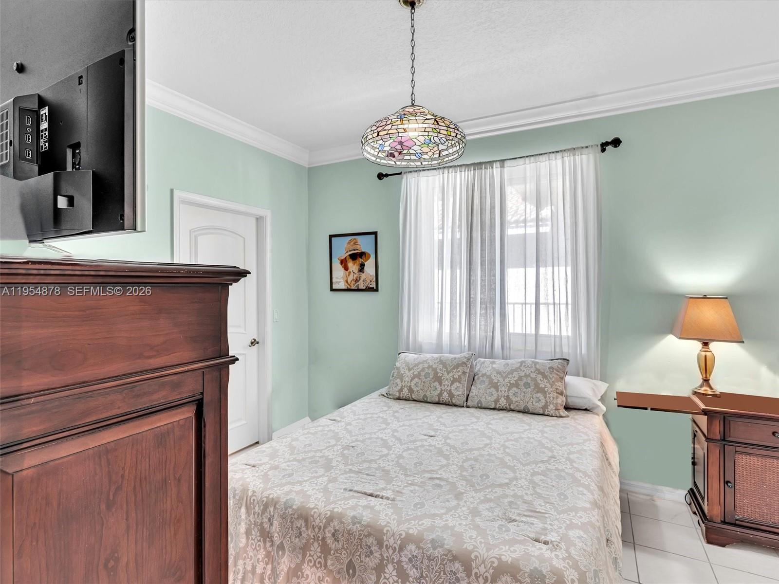 900 Spoonbill Circle Weston, FL 33326 - Photo 34 of 51 a bedroom with a bed and a chandelier